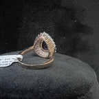 Gold diamond ring with a gemstone on a black cushion
