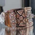 Gold diamond ring with intricate design on a reflective surface