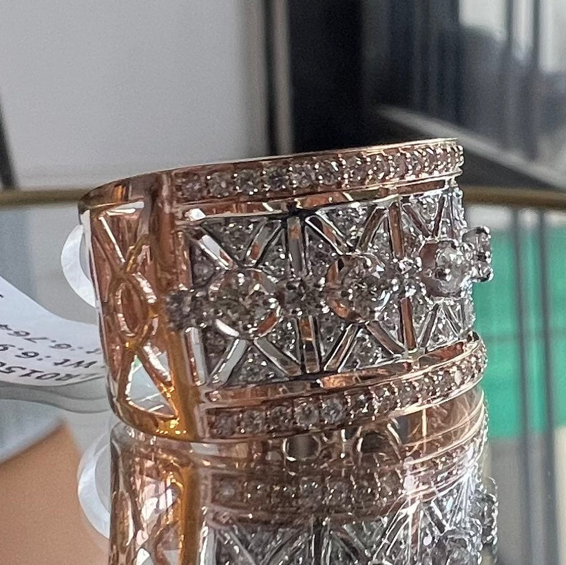 Gold ring with diamond accents on a reflective surface