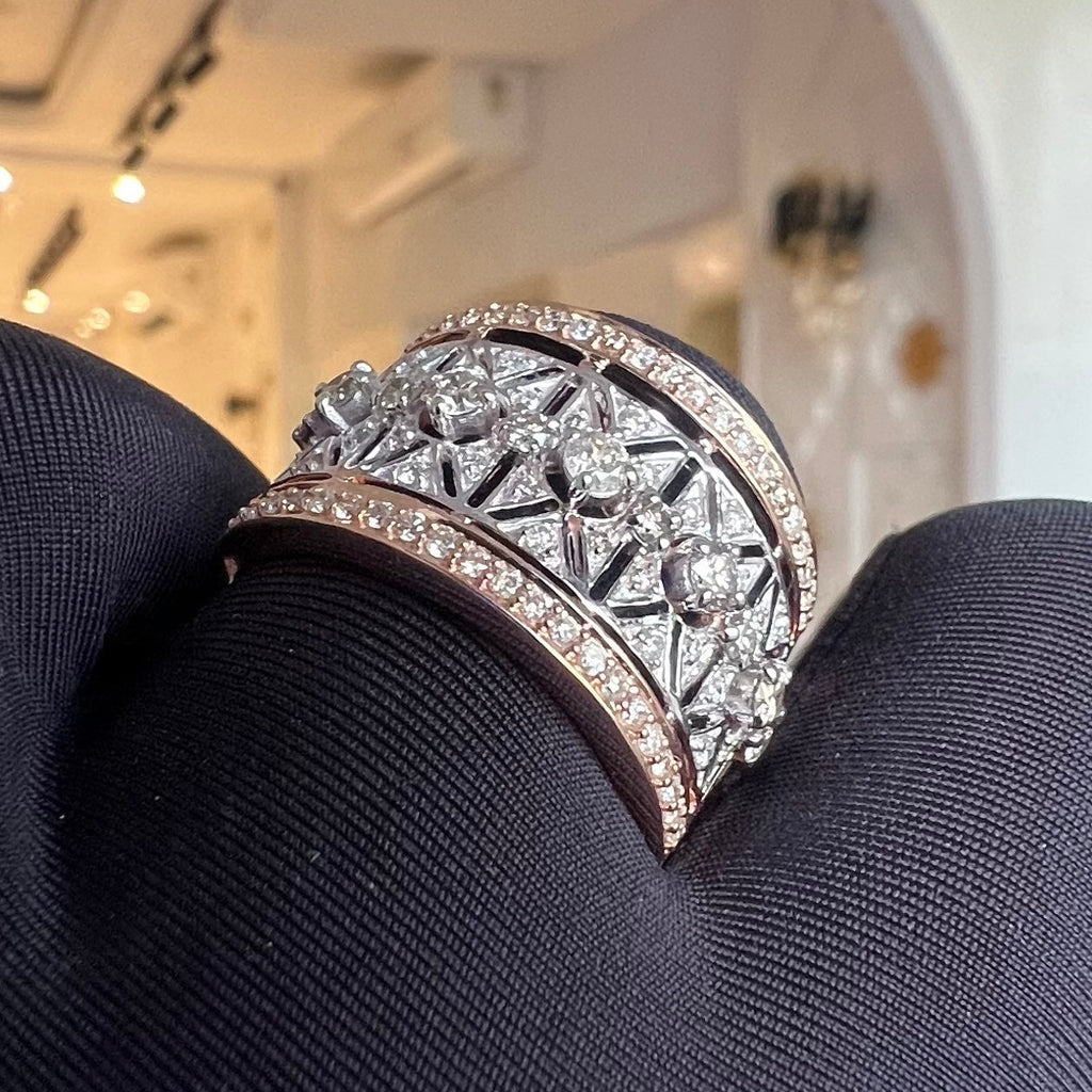 Diamond ring held in dark gloves with a blurred indoor background