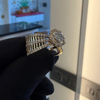 Diamond ring held by a gloved hand against a blurred indoor background