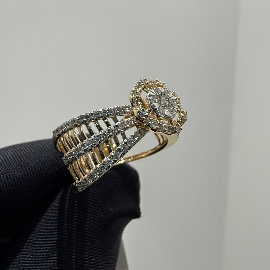 Gold ring with diamond accents on a black stand against a gray background