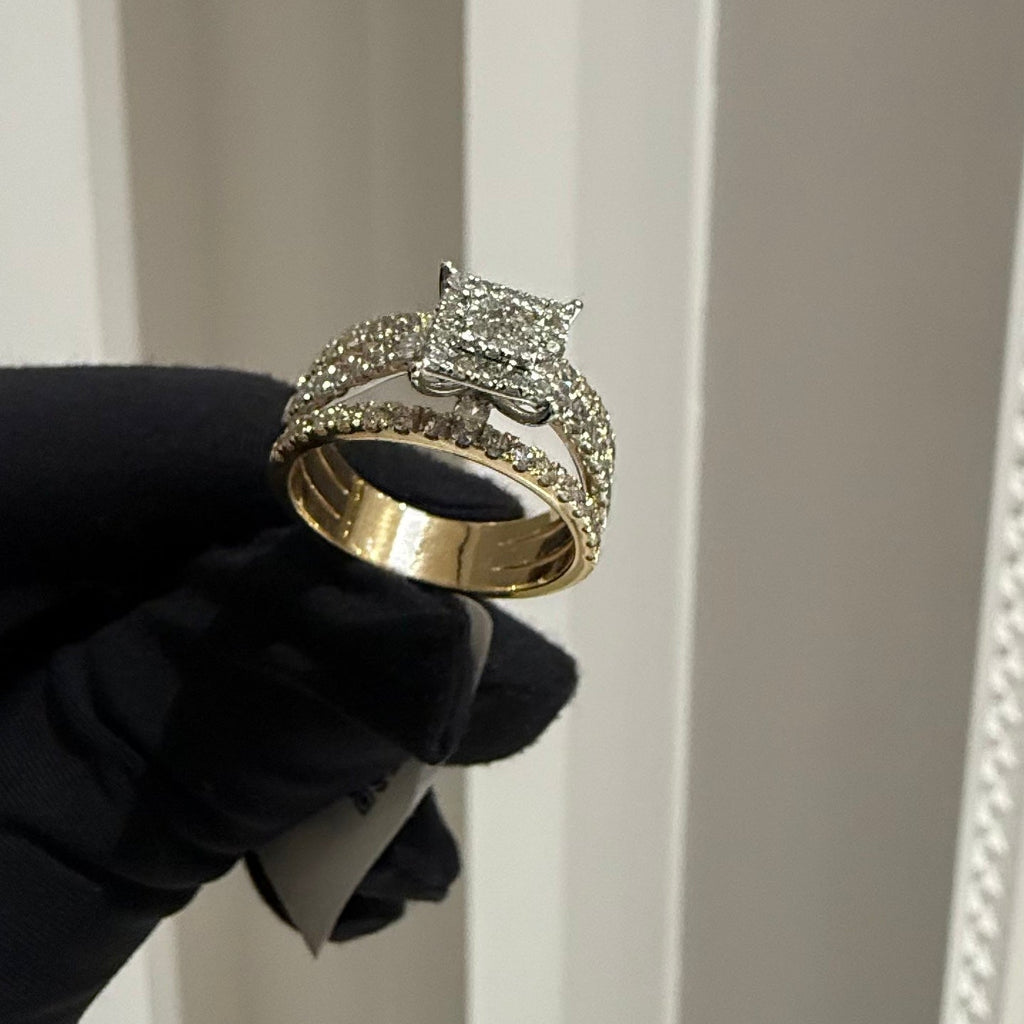 Gold ring with diamond accents held by a gloved hand against a neutral background