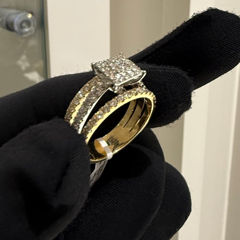 Gold ring with diamond accents held by a gloved hand against a neutral background