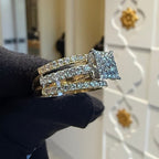 Diamond ring held by a gloved hand with a blurred background