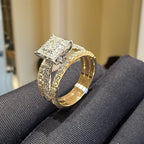 Gold ring with diamond accents on a gray surface