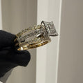 Diamond ring held by a gloved hand against a neutral background