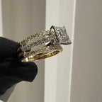 Diamond ring held by a gloved hand against a neutral background