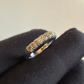 Diamond ring on a black cushion with a neutral background