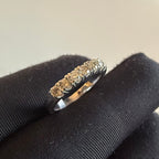 Diamond ring on a black cushion with a neutral background
