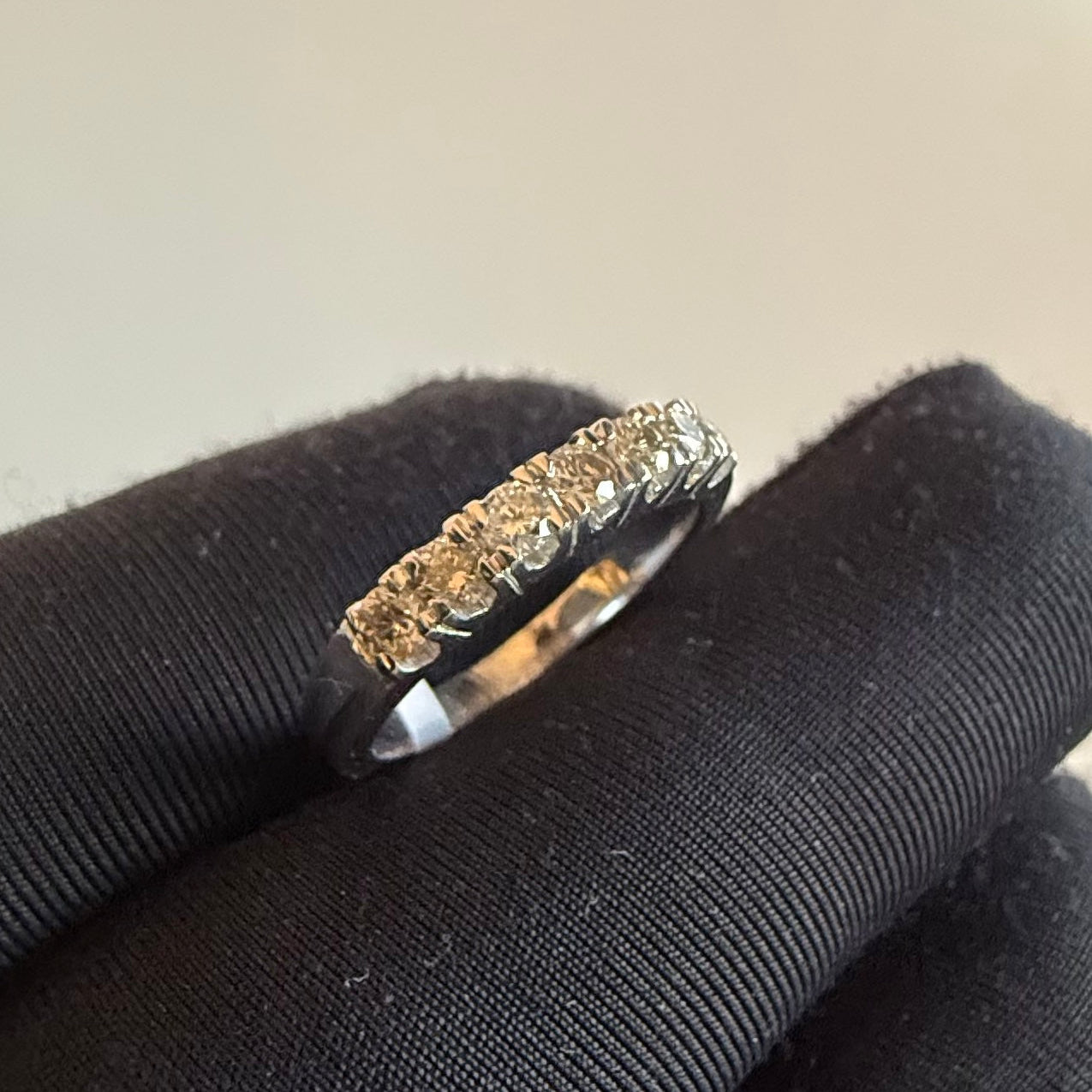 Diamond ring on a black cushion with a neutral background