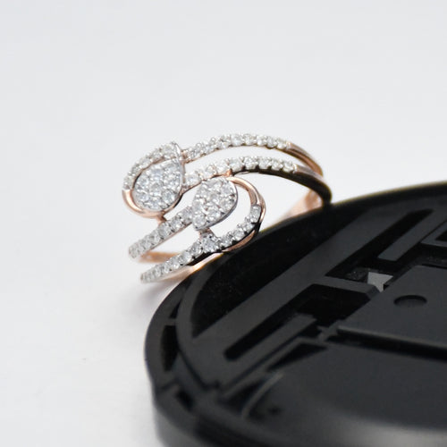 Rose gold and diamond ring on a black surface with a white background
