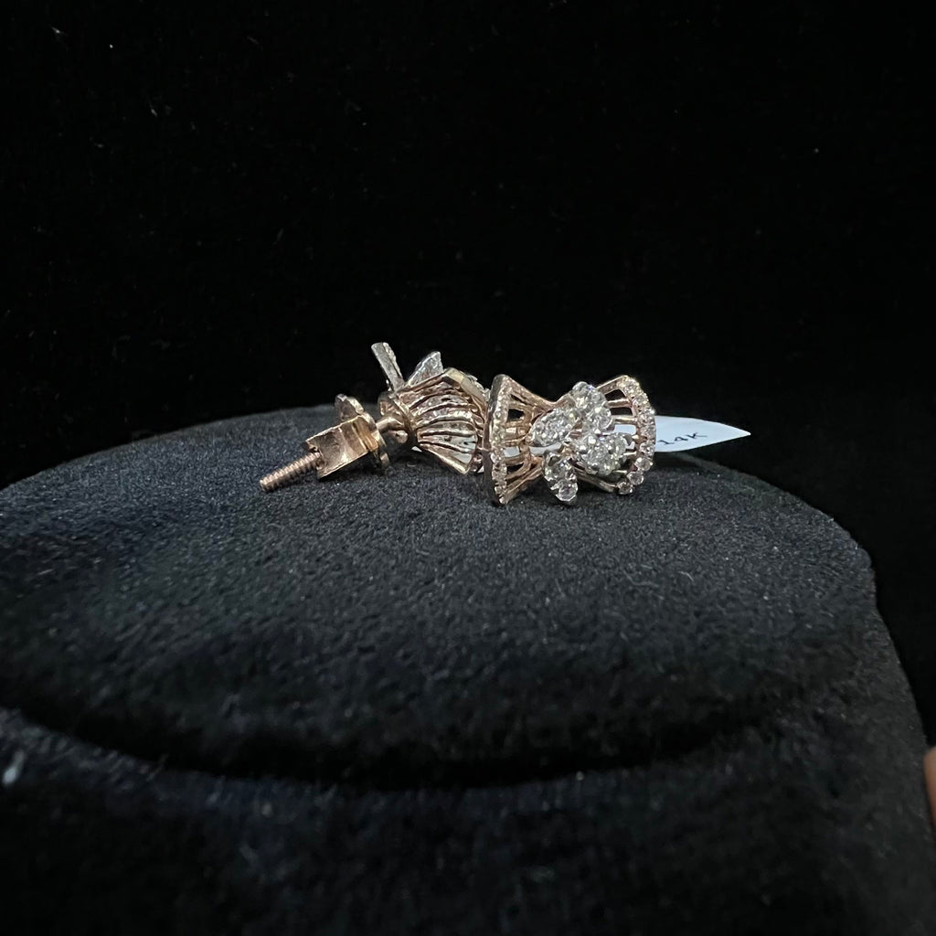 Diamond earrings on a black cushion with a dark background