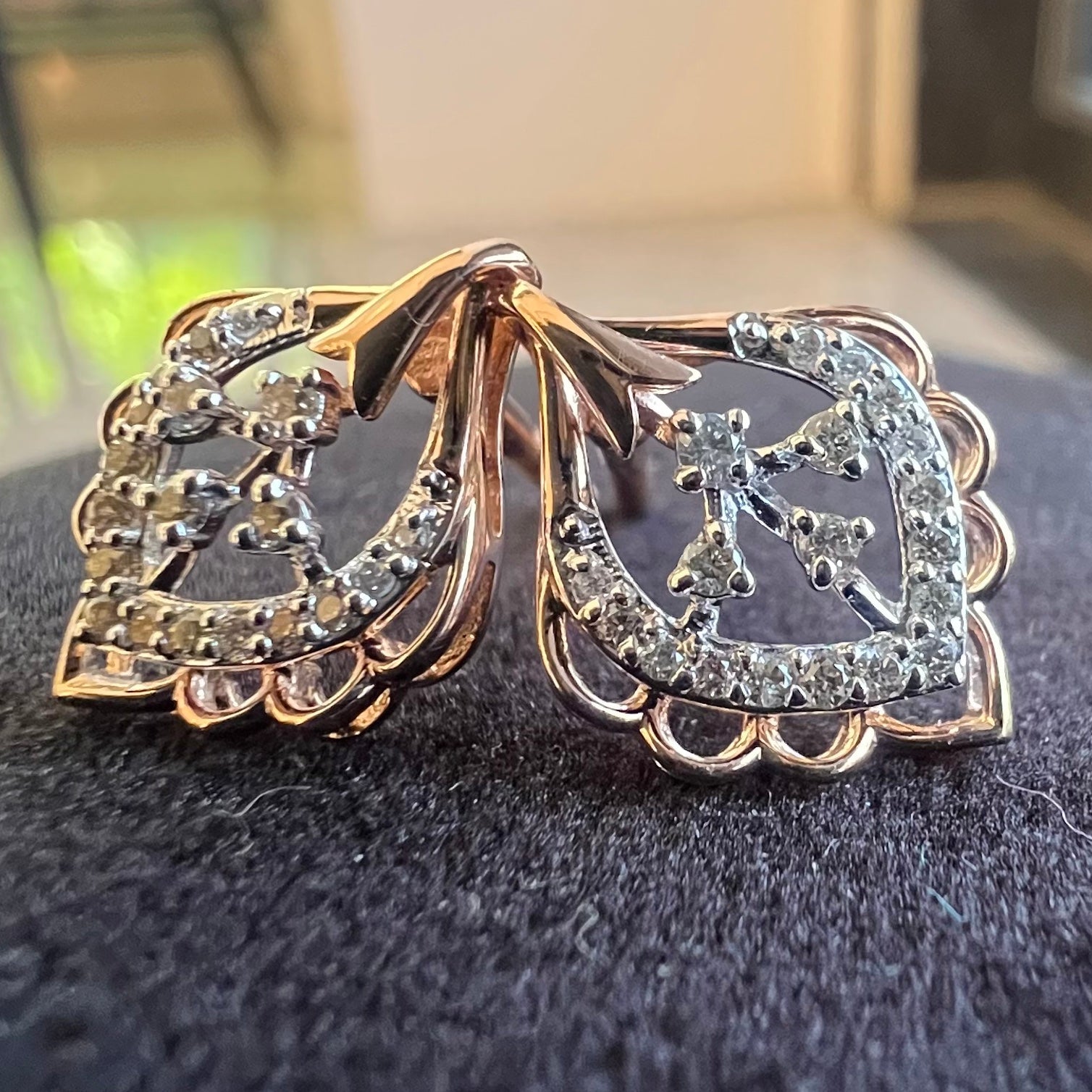 Pair of gold earrings with diamonds on a dark surface