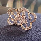 Gold butterfly-shaped earrings with diamonds on a dark textured surface