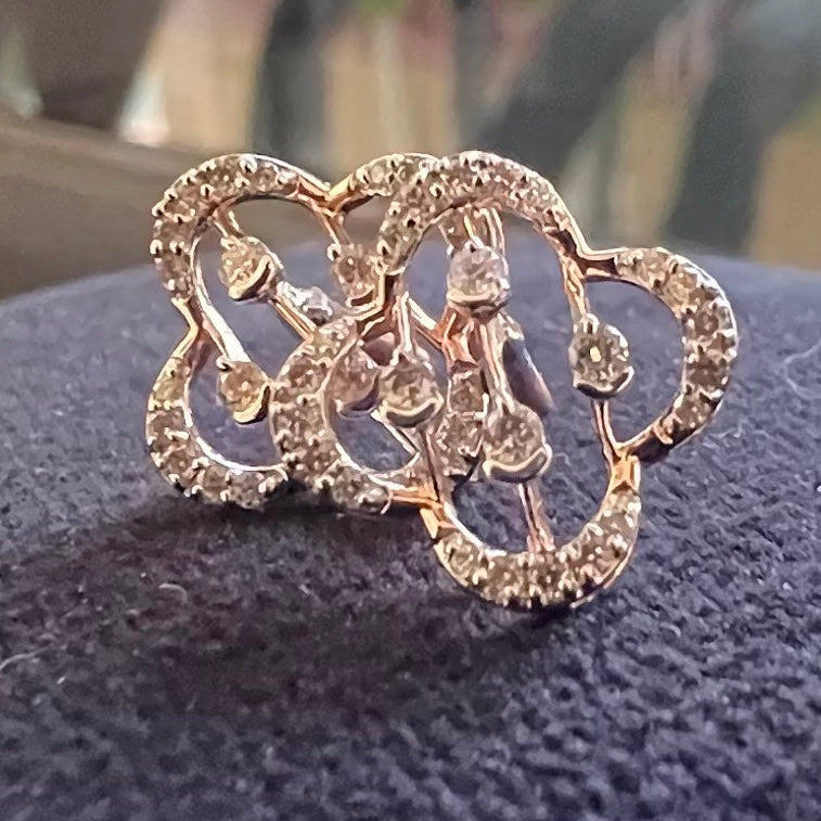 Gold butterfly-shaped earrings with diamonds on a dark textured surface