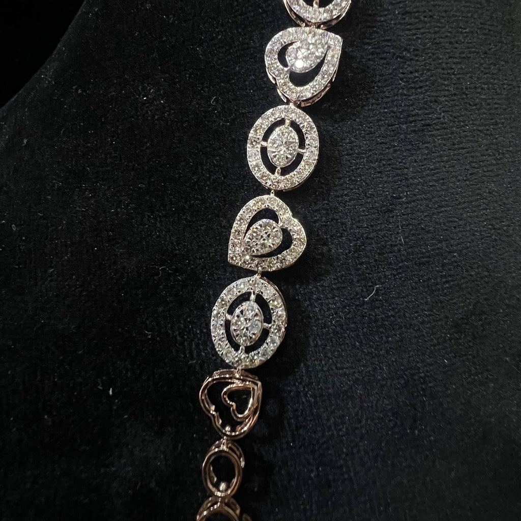 Gold bracelet with heart-shaped diamond designs on a black background