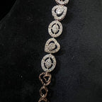 Gold bracelet with heart-shaped diamond designs on a black background
