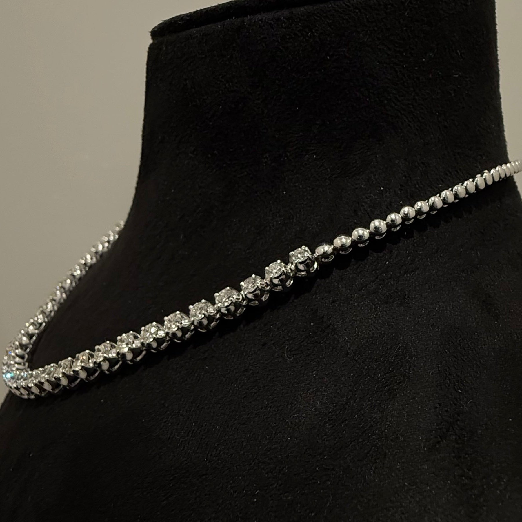 White gold diamond tennis necklace on a black mannequin bust