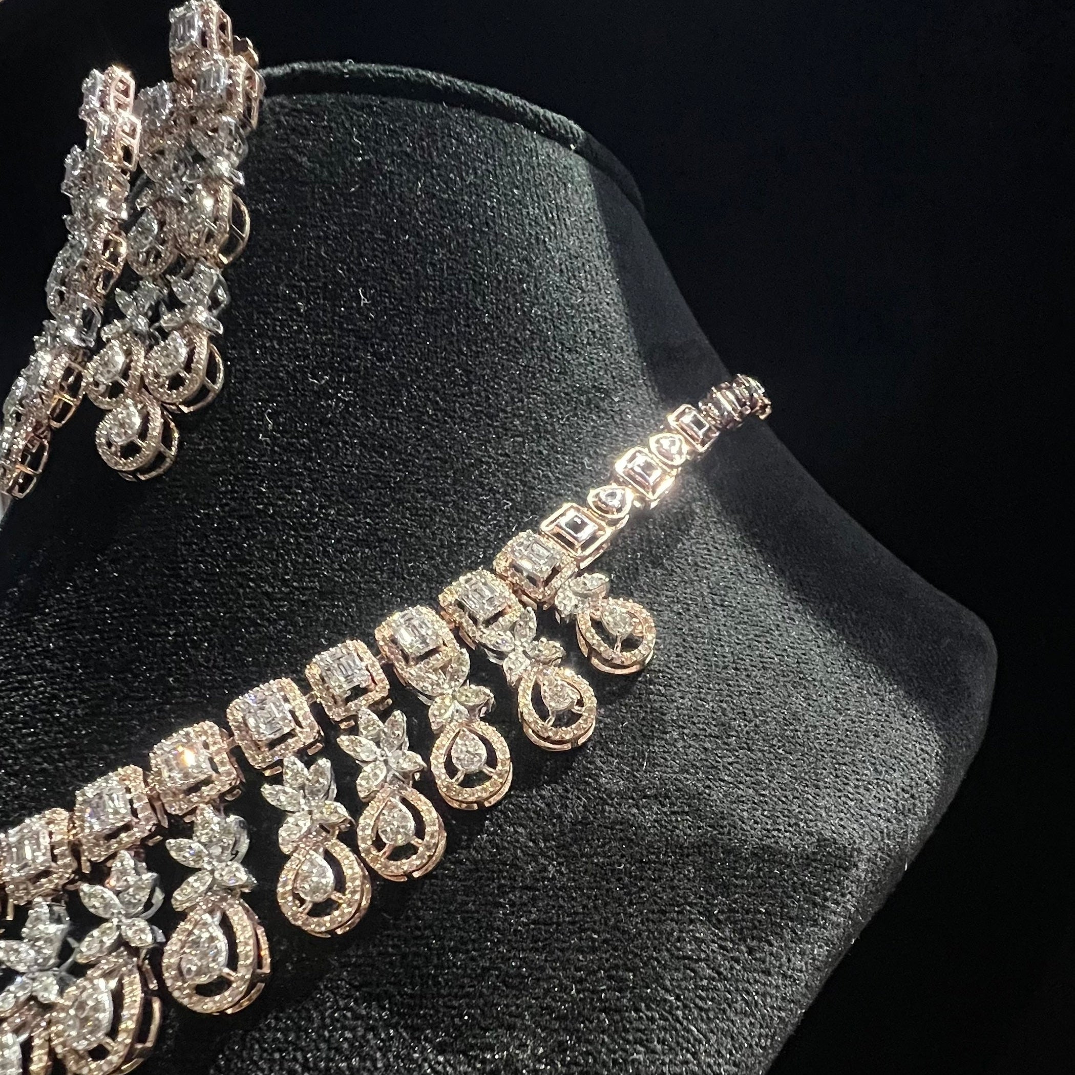 Diamond necklace and earrings on a black stand