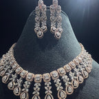 Diamond necklace and earrings on a black stand with a dark background