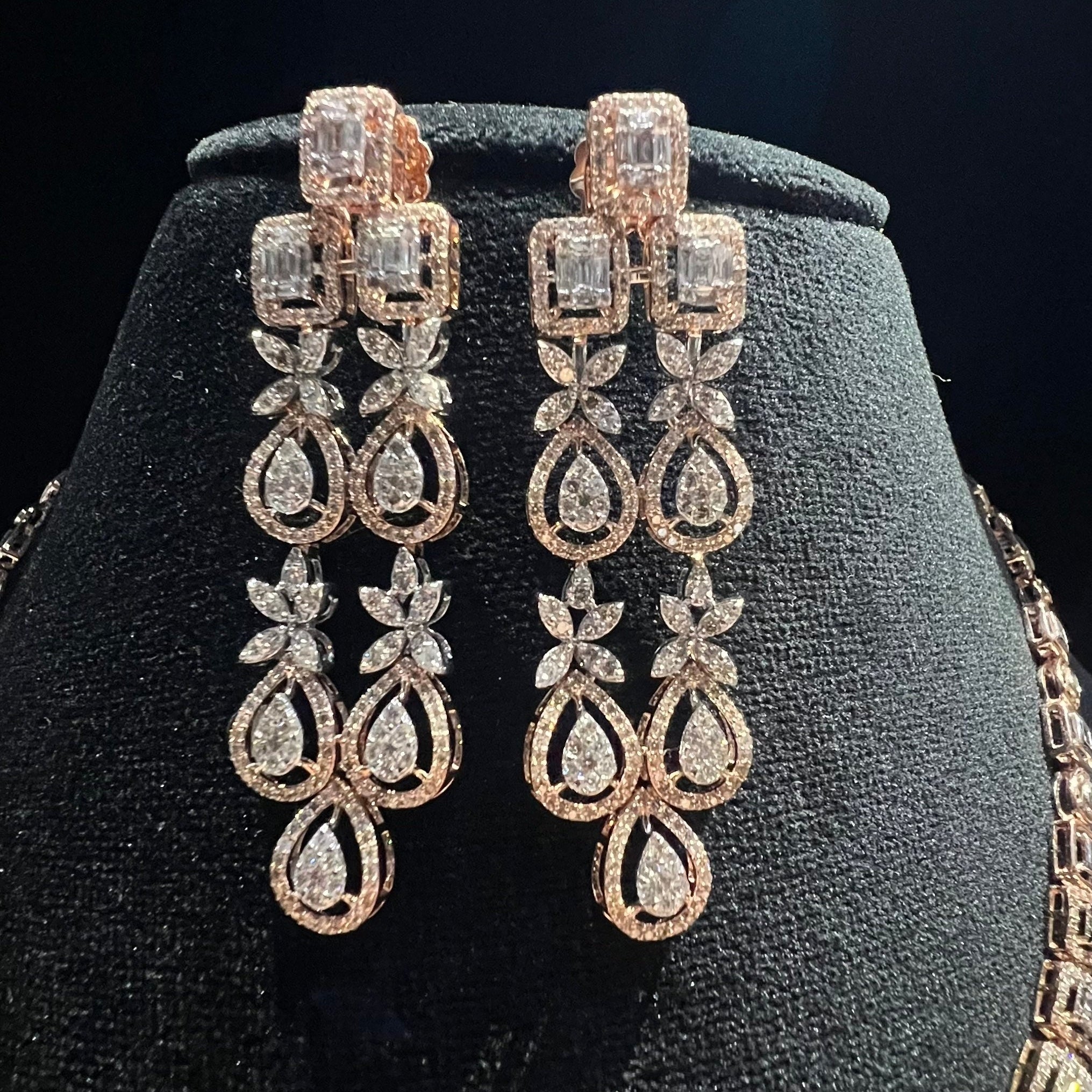 Pair of diamond earrings on a black jewelry stand